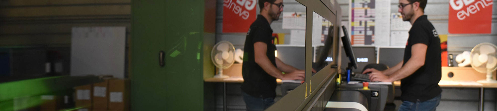 Employé sur imprimante numérique de signalétique GL events