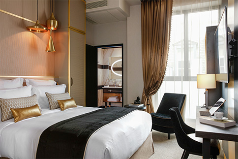 Agencement chambre hôtel Niepce : lit, tête de lit, table de chevet, armoire