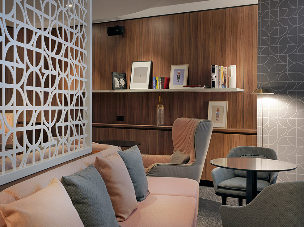 Agencement espace commun d'hôtel : canapés, fauteuils, table, claustra