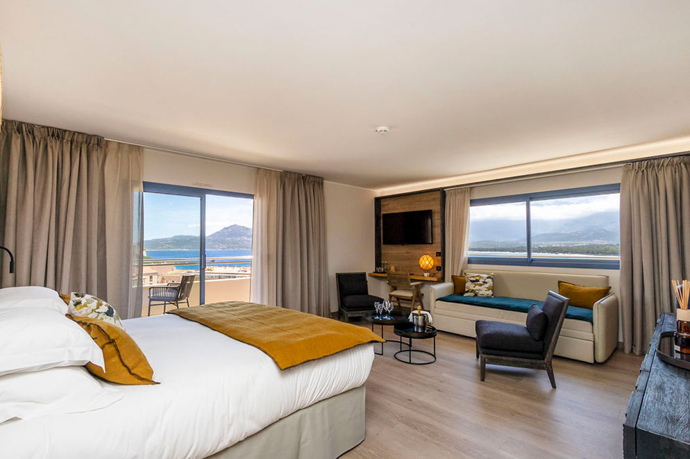 Agencement chambre Hôtel L'Acquale Calvi Suite Prestige : tête de lit, meuble tv...