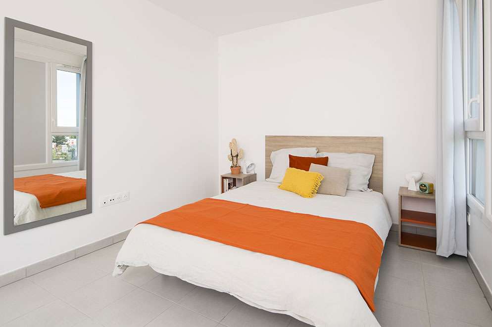 Agencement chambre étudiante : lit, table de chevet, miroir  