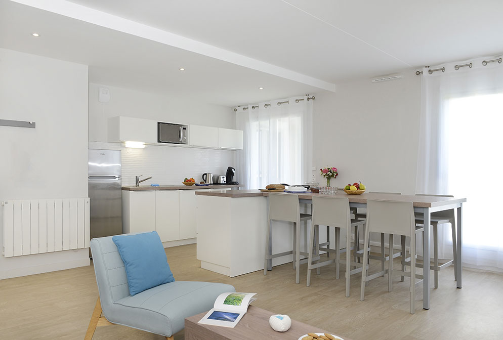 Agencement d'un appartement : fauteuil, table et chaises hautes, meuble