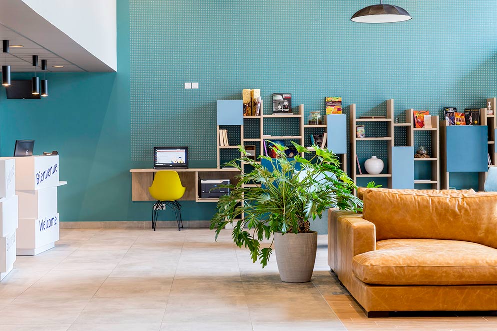 accueil de l’hôtel avec bibliothèque et canapé