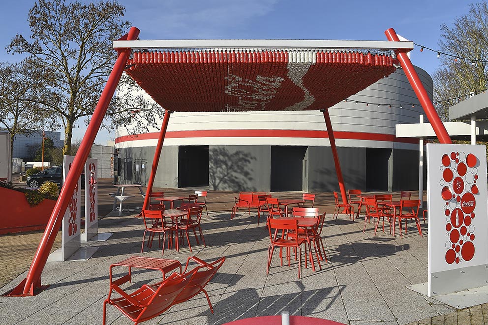 Pergola design Coca-Cola et mobilier rouge en accord : tables et chaises