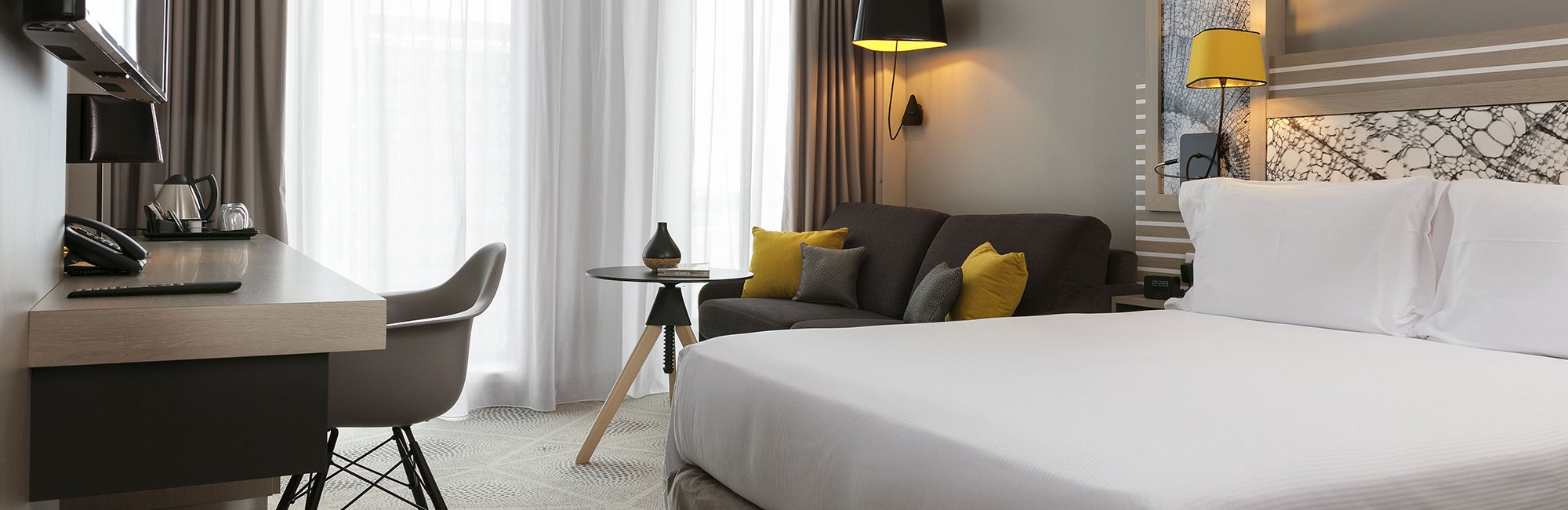 Agencement chambre HÔTEL HILTON GARDEN INN BORDEAUX : lit, canapés, table