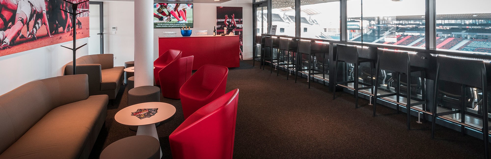 Agencement espace VIP : loges avec canapés, bar, mange-debout et signalétique
