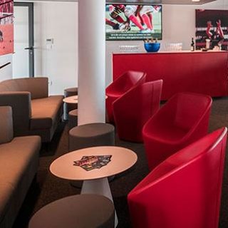Agencement espace VIP : loges avec canapés, bar, mange-debout et signalétique