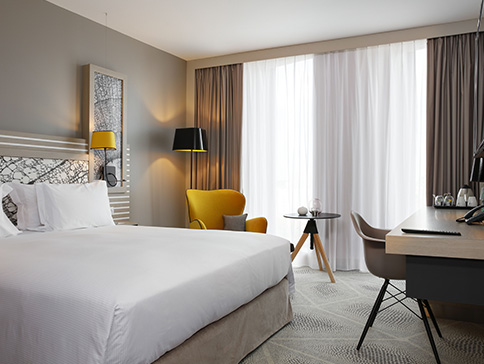 Agencement d'une chambre d'hôtel - lit, bureau, fauteuil, chaise, table