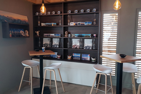 Agencement d'un espace commun de détente : tables hautes, chaises hautes, étagères