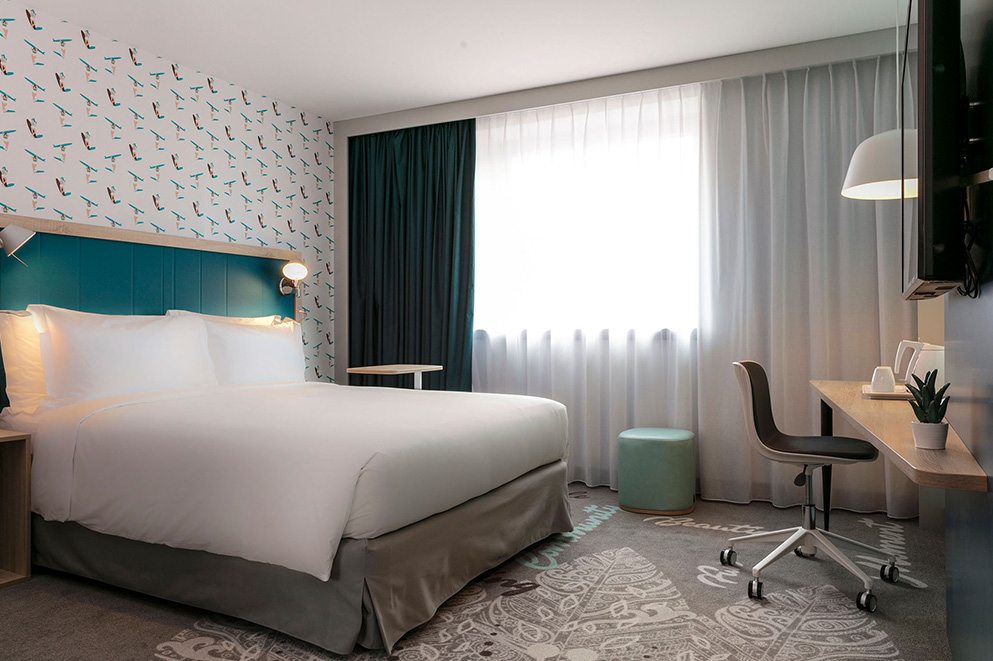 Agencement d'une chambre d'hôtel : lit, bureau, chaise