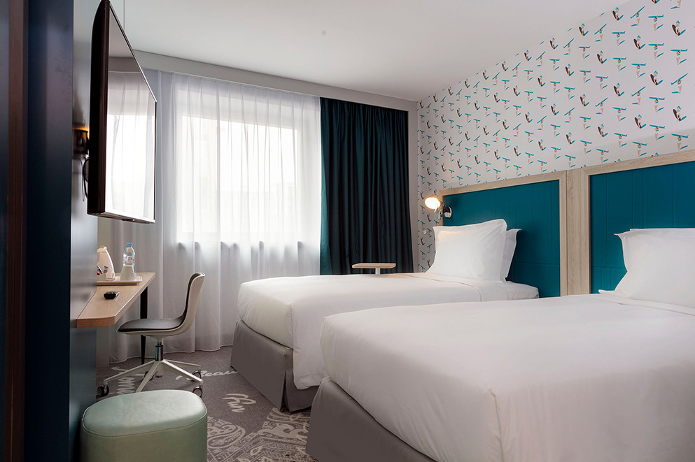 Agencement d'une chambre d'hôtel : lit, bureau, chaise