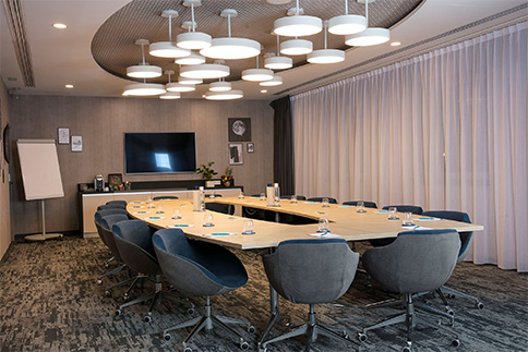 Agencement d'une salle de séminaire : bureaux, fauteuils, lustres